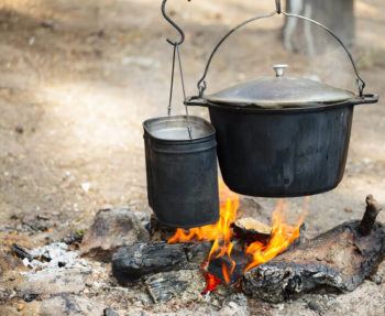 Boiling water at a campfire is an example of changing temperature as a result of a change in energy. Energy is added to the water from the fire, increasing the kinetic energy of the water.