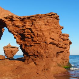 Rock formation near water with natural arch