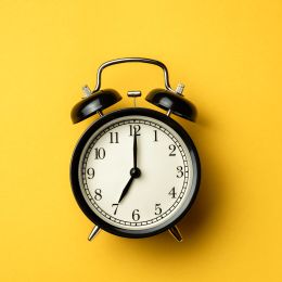 alarm clock showing 7:00 on a yellow background