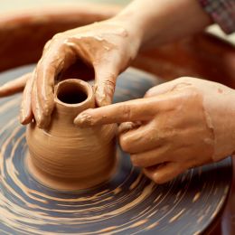 pottery person making a clay vase on a spinning wheel