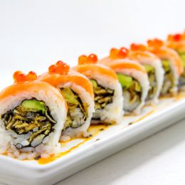 sushi roll arranged into a line on a long white plate