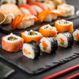 multiple plates of different kinds of sushi and sashimi