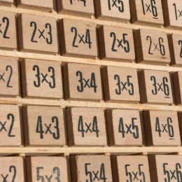 wooden block board showing many multiplication problems to be solved
