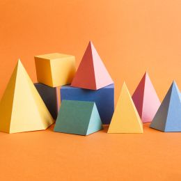 colorful geometric building blocks stacked on one another on an orange background