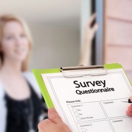 survey questionnaire on a clipboard with woman in background