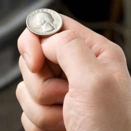 a quarter coin about to be flipped on a finger
