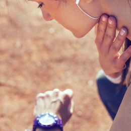 woman checking her own pulse while exercising outside