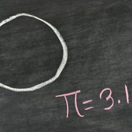 circle and the number pi drawn on a black chalkboard