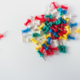 thumbtacks of various colors in a pile