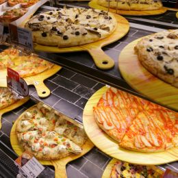 many pizzas on display in store