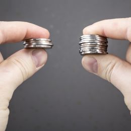person holding 2 stacks of coins