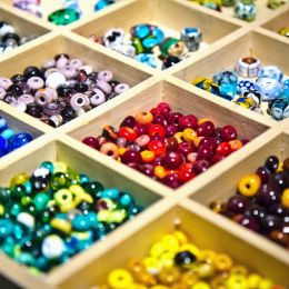 a lot of colorful beads in square wooden storages